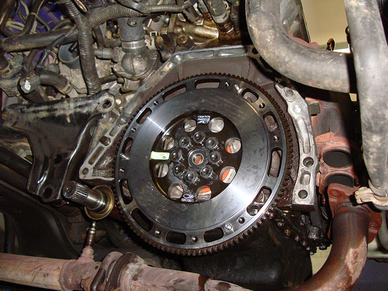 Here, new ARP bolts are being used to secure the flywheel to the crankshaft. These should be torqued down to ARP specs. The company also supplies a thread lubricant to ensure proper torque. You also might notice the new rear crank seal hiding behind the flywheel (orange). Flywheel Installed