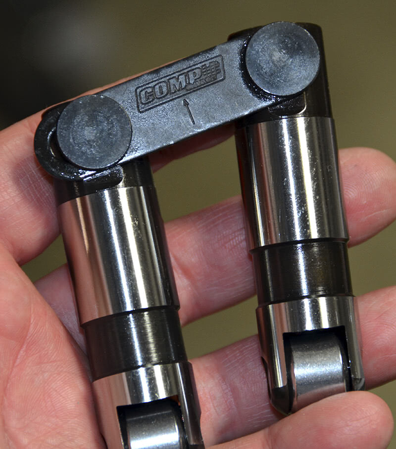 This is a pair of Comp full length hydraulic roller lifters that utilize a link bar system. You can see the arrow pointing up -- the link bar faces inside the valley. This lifter has about the same amount of travel as the flat hydraulic, about .150 in. total plunger travel.